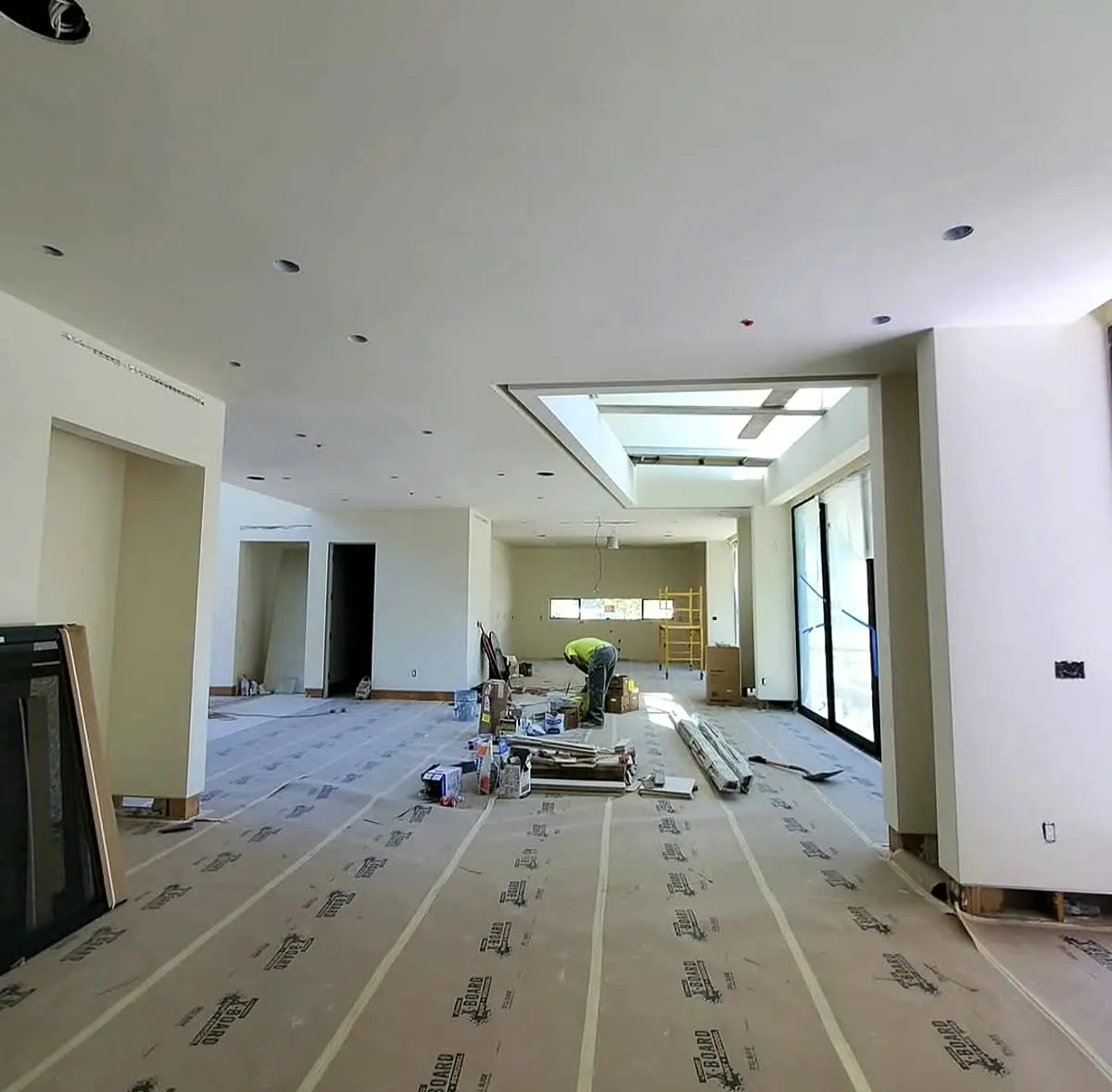 Drywall finisher on stilts patching and finishing a hallway ceiling — Hallway Finish
