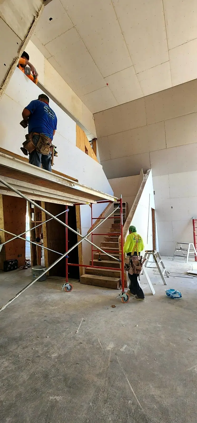 GR Quality Drywall crew installing drywall from scaffolding on a high ceiling in Los Angeles — High Ceiling Crew